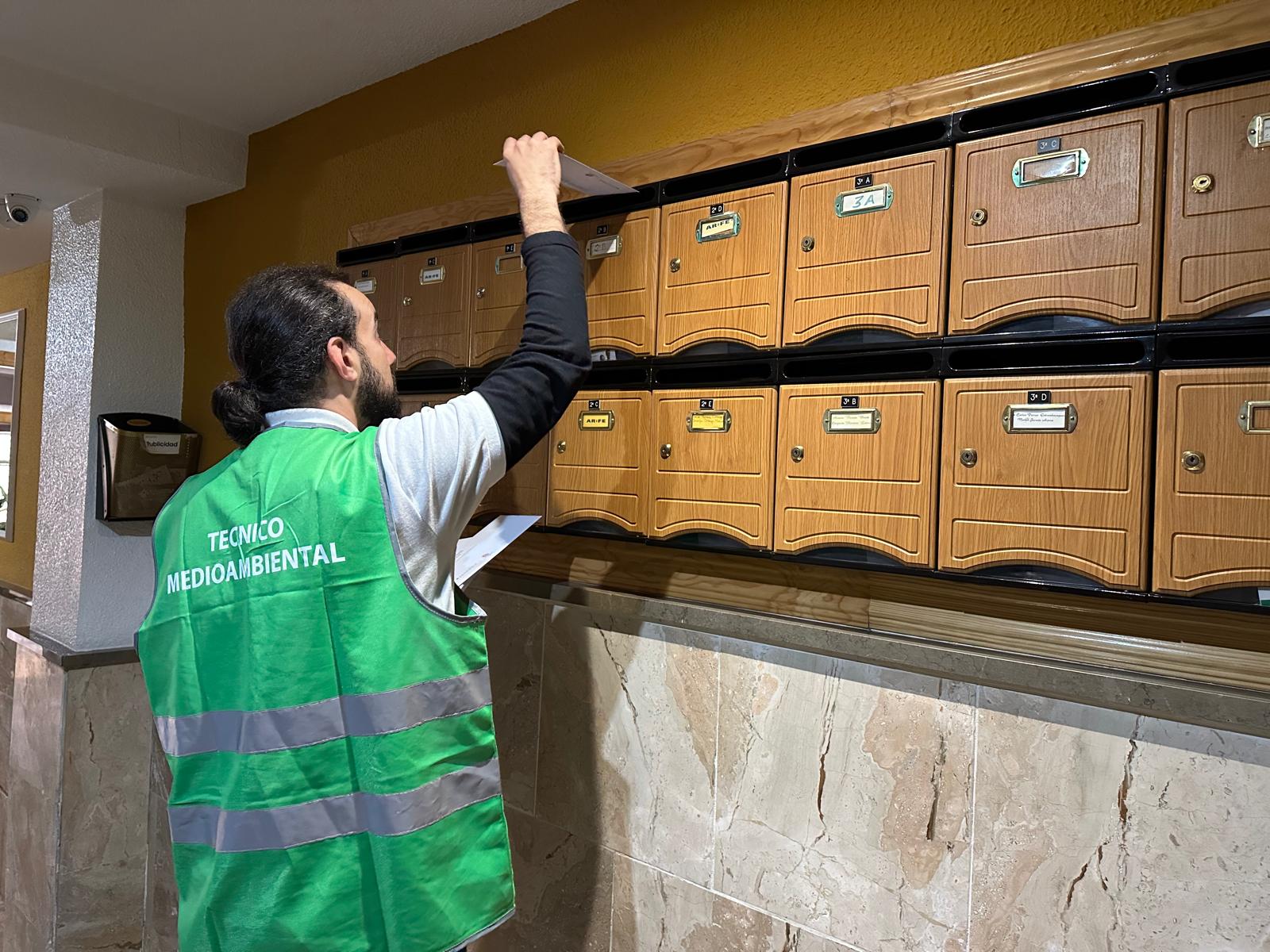 Un técnico medioambiental deposita folletos de la campaña en un buzón de Jaén.